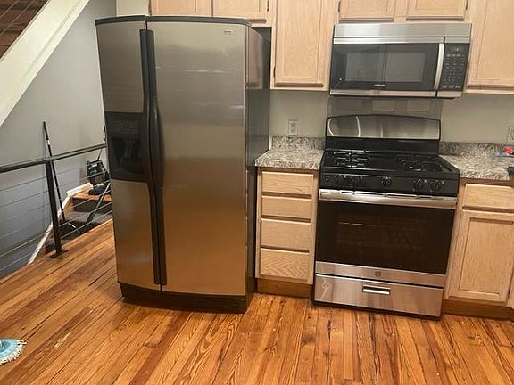 stainless steel refrigerator and gas stove. Also overhead microwave