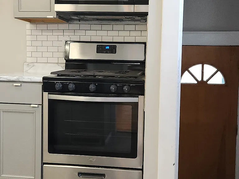View of kitchen to basement steps and back door.