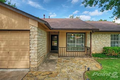 Shaded stone patio and front porch welcome you to this charming home.