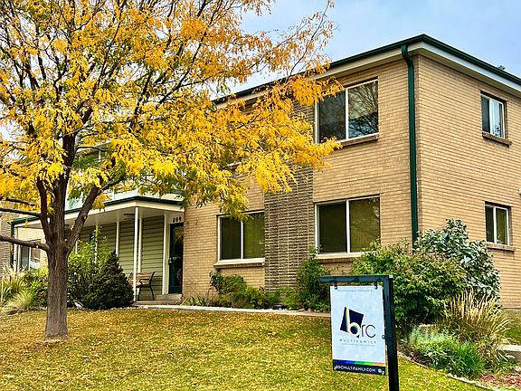 Explore the inviting exterior of this charming brick apartment, surrounded by nature.