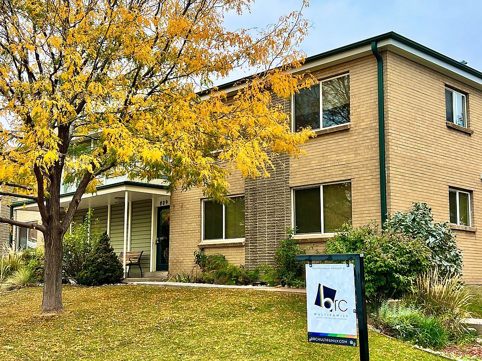 Explore the inviting exterior of this charming brick apartment, surrounded by nature.
