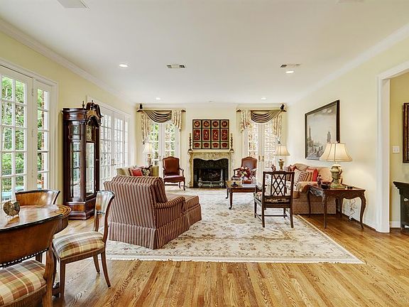 You will love this living room with hardwood floors, crown molding, recessed lighting, two sets of double 18-pane French doors framed by matching 6-pane sidelights overlooking the main floor outdoor balcony terrace, two sets of matching double 18-pan