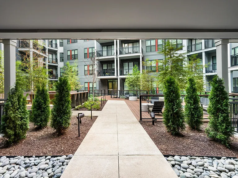 Lushly landscaped courtyard featuring cozy fire pits, ample seating, and modern finishes_perfect for relaxing or socializing just steps from home.