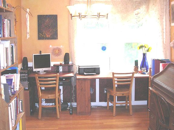 Dining Rm. with hardwood floor, looks over backyard and is being used as den