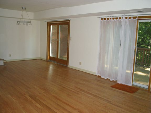 Dining room/ living room with hardwood floors and two large