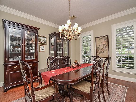 Formal dining with crown molding, hardwoords, and plantation shutters!