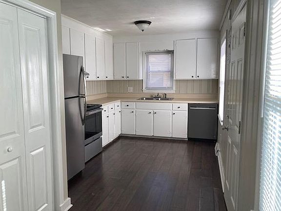 Kitchen with new stainless-steel fridge, dishwasher, range and range hood. Large laundry closet seen on left in photo.