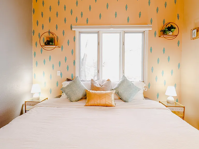 A cozy setting with yellow and gray walls, enhanced by the soft glow of a lamp and the modern touch of a TV, creating a welcoming and comfortable atmosphere.