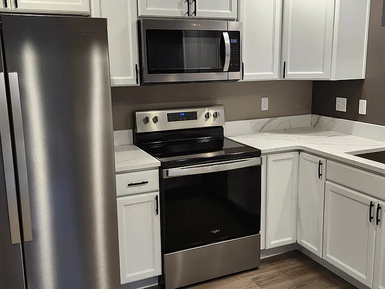 Kitchen with stainless-steel appliances & quartz counter tops.