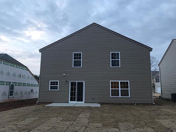 Back of the home with large concrete patio