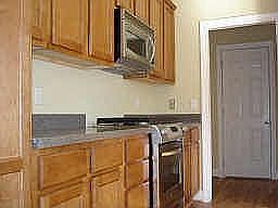 Gourmet kitchen with stainless appliances and maple cabinets.