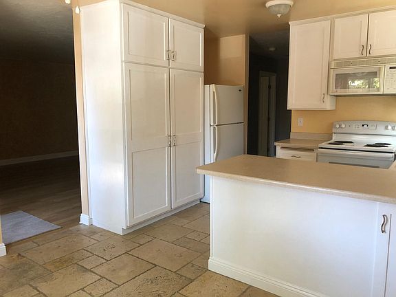 View of kitchen featuring large storage pantry and refrigerator -