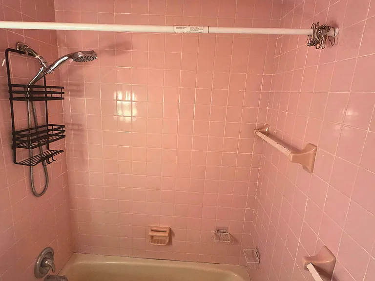 Spacious tub and shower combo for a relaxing and comfortable experience.
