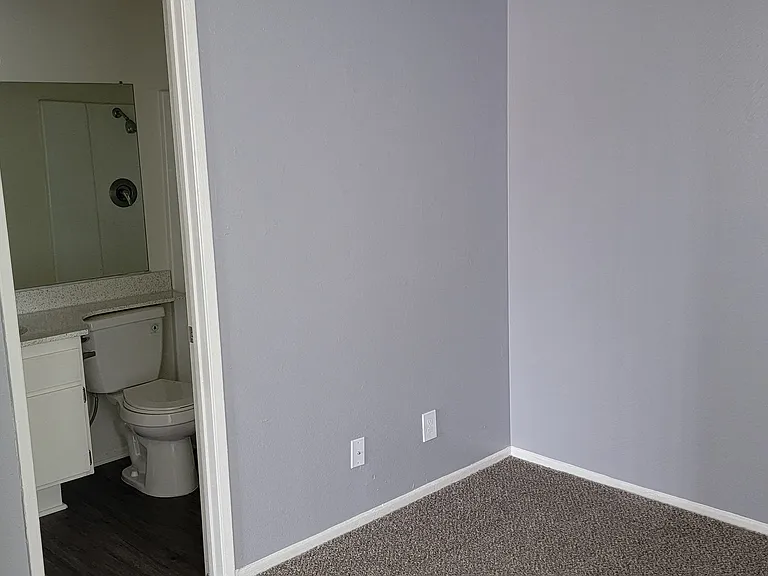 Bedroom with private bathroom at Grand Oaks Apartments in Lake Elsinore, California.