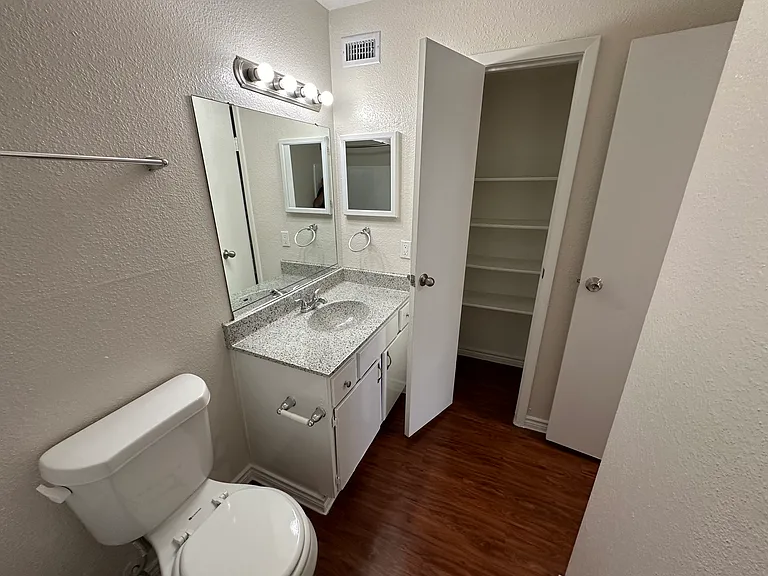 Contemporary bathroom featuring a sleek granite countertop, modern lighting, and a spacious linen closet. Contemporary bathroom featuring a sleek granite countertop, modern lighting, and a spacious linen closet.