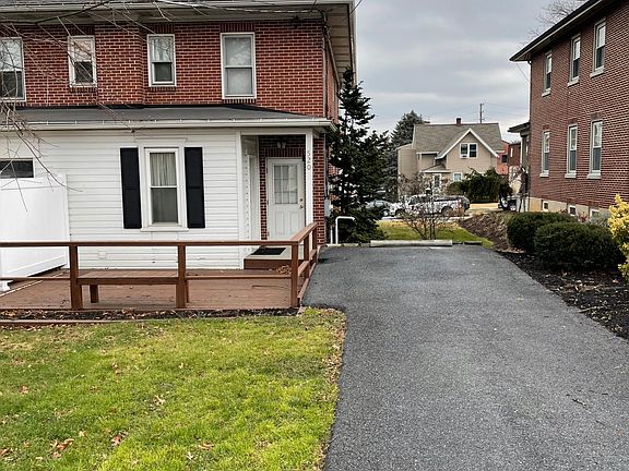 Driveway and deck. Parking. Back entrance is viewed in this picture.
