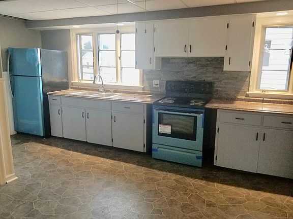 Extra large, eat-in kitchen with white and grey cabinets 
