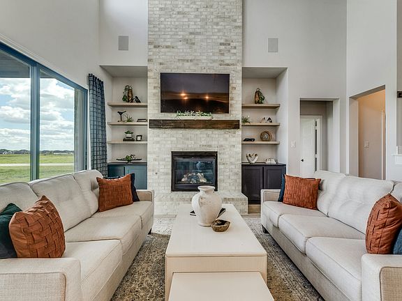Living room with TV inside Berkshire Estates home in Mesquite, TX by Kindred Homes
