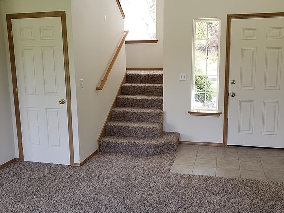 Living room looking at front door, closet and the stairs.