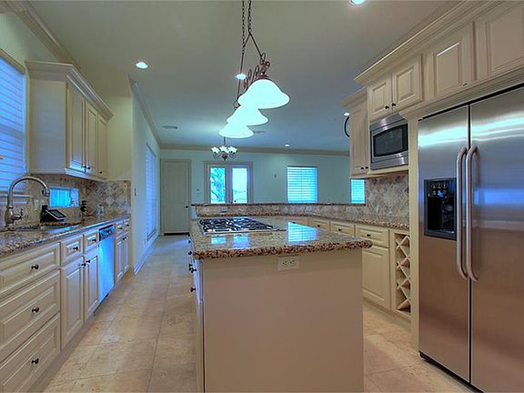 Kitchen with gas cooktop in Island.  Side-by-Side Stainless Steel Refrigerator included.
