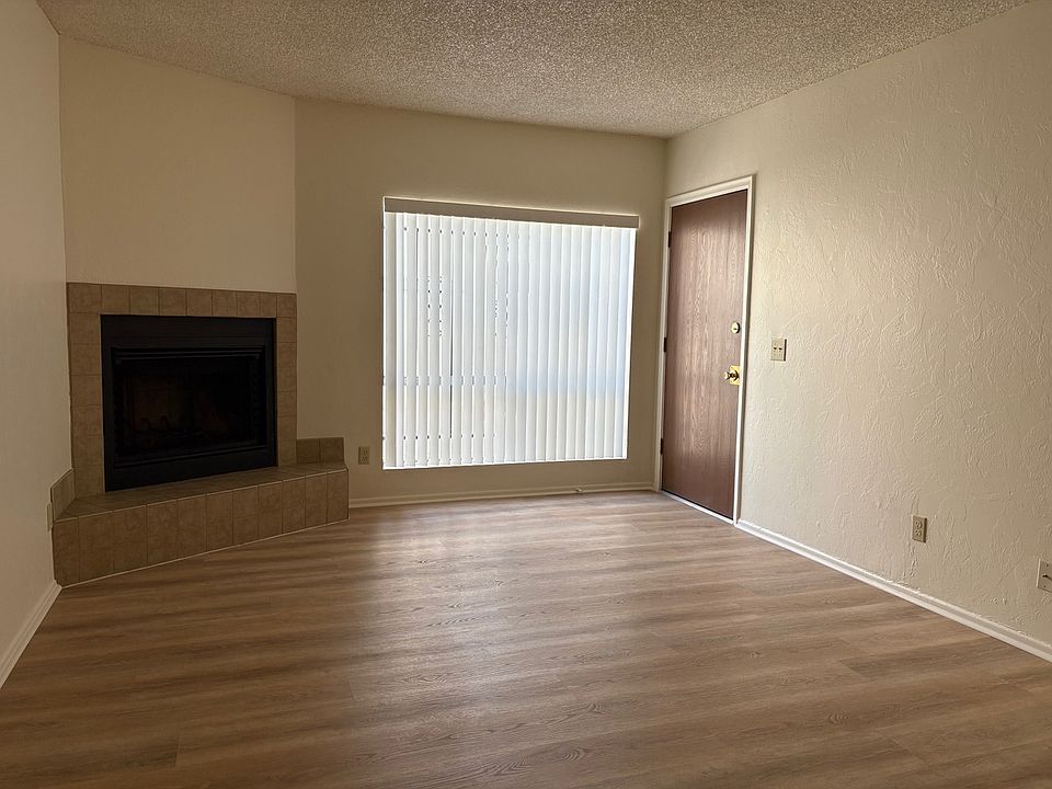 Living room showing large window, fireplace, wood grain (LVP) flooring