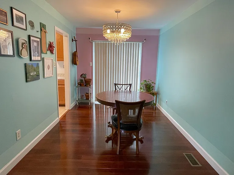 Dining room with crystal chandelier opens into the living room as well as onto the back deck.