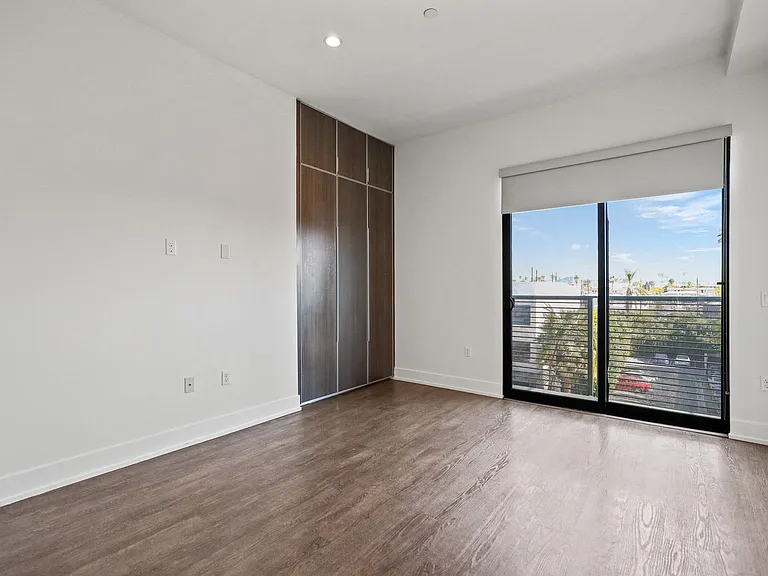 Bedroom with Built-In Cabinet Storage, Recessed Lighting, and Balcony with Windows with Shades