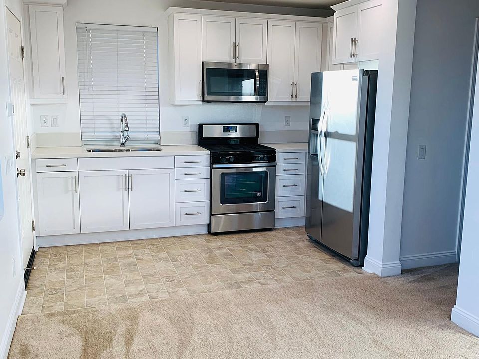 Full kitchen with stainless steel gas range, microwave, and refrigerator with water filter and icemaker.