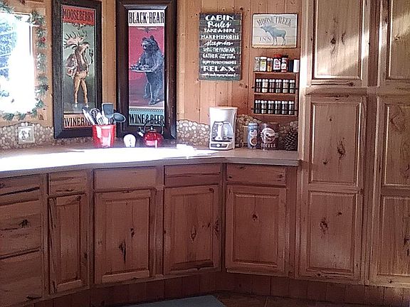 lodgy decorated kitchen with hickory cabinets and pebble tile backsplash