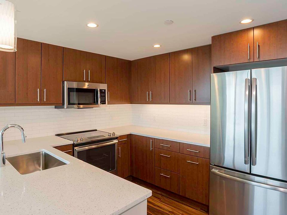 Open kitchens with stainless steel appliances, ample quartz countertop space, and French door refrigerator
