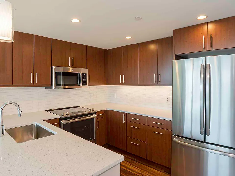 Open kitchens with stainless steel appliances, ample quartz countertop space, and French door refrigerator