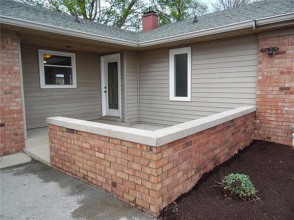 Brick wall tastefully provides definition for the open front porch. Add your table, umbrella, & chai