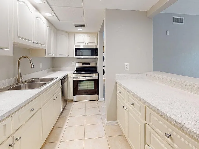 Bright, modern kitchen with sleek white cabinetry, stainless steel appliances, and elegant countertops.