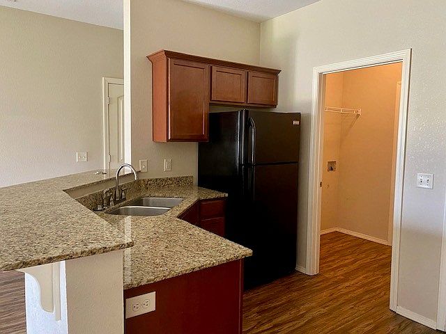 Stainless steel kitchen sink and washer/dryer connection off kitchen.
