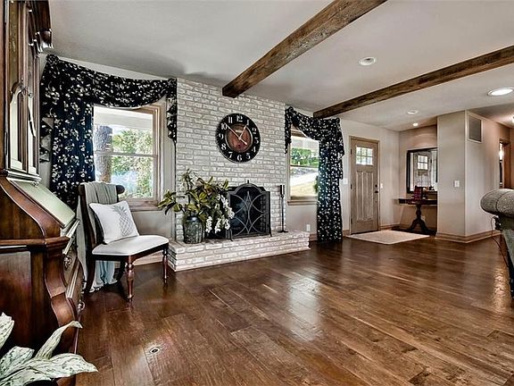 This Remodel is Picture Perfect with Painted Fireplace, Exposed Wood Beams & Gorgeous Wood Flooring...