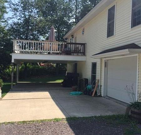REAR GARAGE DOOR, CARPORT AND DECK WHICH IS ACCESSED FROM KITCHEN