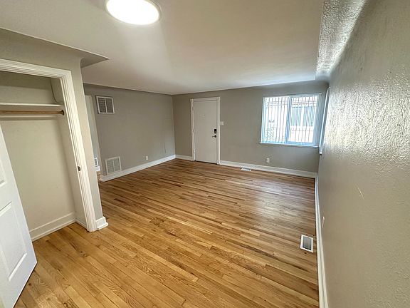 Bright room with elegant hardwood flooring, complemented by natural light streaming through large windows, creating a warm and inviting atmosphere.