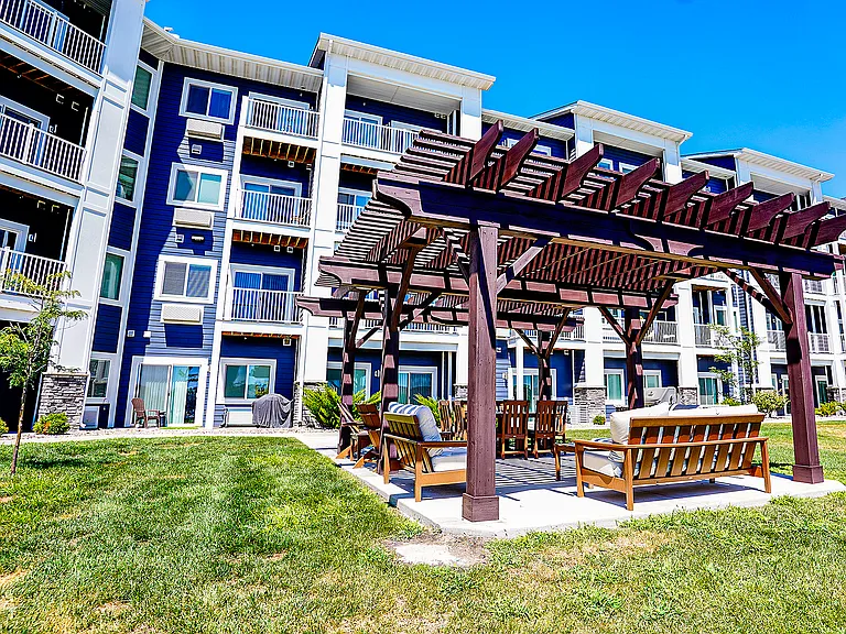 Amenities include an outdoor lounge under a pergola.