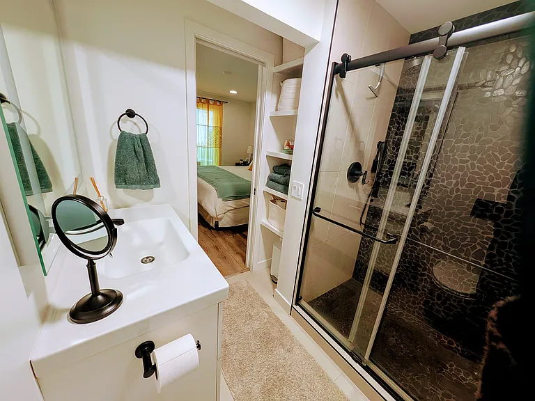 Primary bedroom - ensuite bathroom with walk-in shower, plenty of storage, pocket door, and view of the primary bedroom.