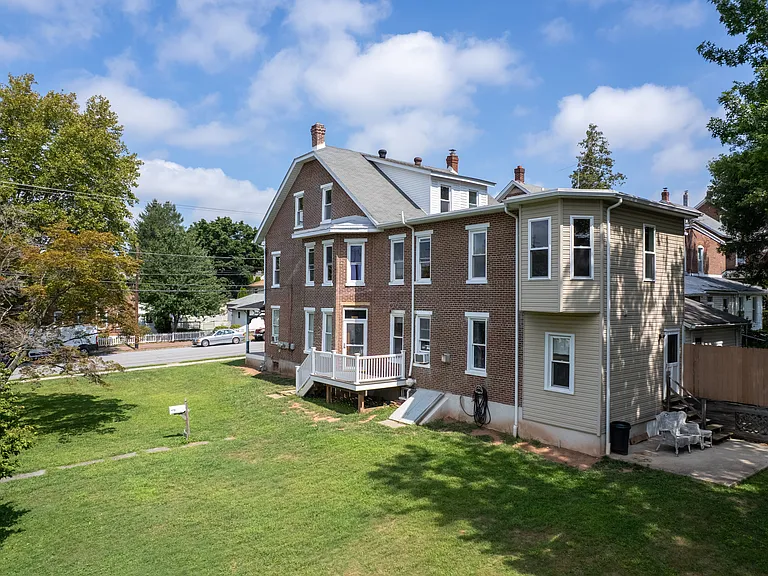 Back of the side yard showing the first floor tenants porch and back entrance. The yard is a shared space for tenants, and the upstairs tenant is encouraged to use the front half of the yard.
