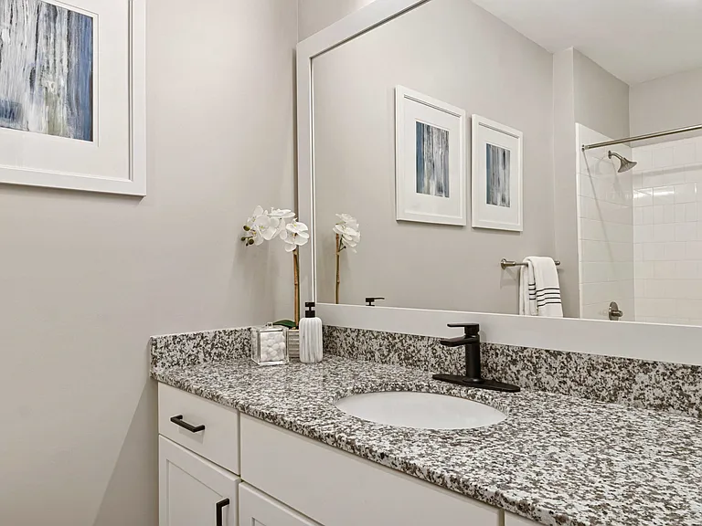 Upgraded Baths with Framed Mirrors and Matte Black Fixtures