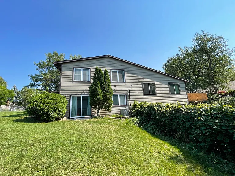 View from the backyard of the home. Sliding door is an entrance to the lower level of the home.