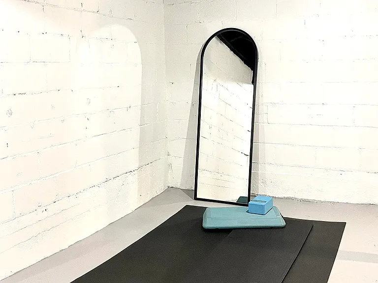 The yoga workout area next to the laundry station is equipped with small weights, a mat, a mirror, and a step, making it ideal for unwinding at the end of the day or starting your morning with a workout while your laundry dries.