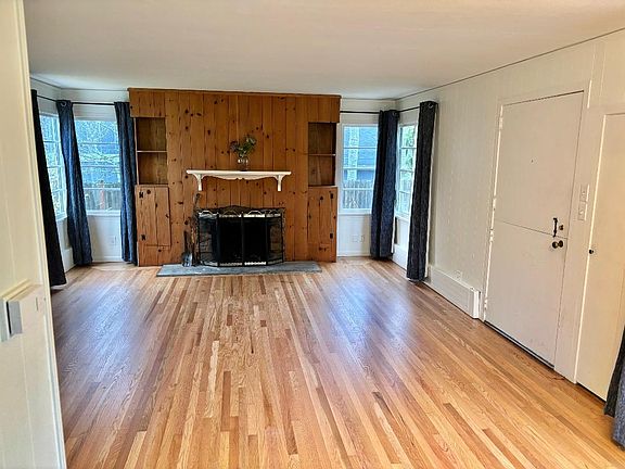 Large living room with a wood burning fireplace. Refinished floors . Fresh paint through-out.
