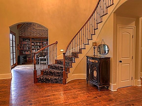 Entry With Curved Staircase Looking Into Library