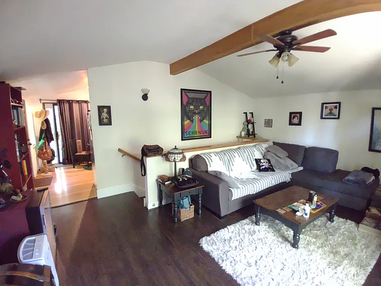 Living room with wood floor with a view of dining room in the back