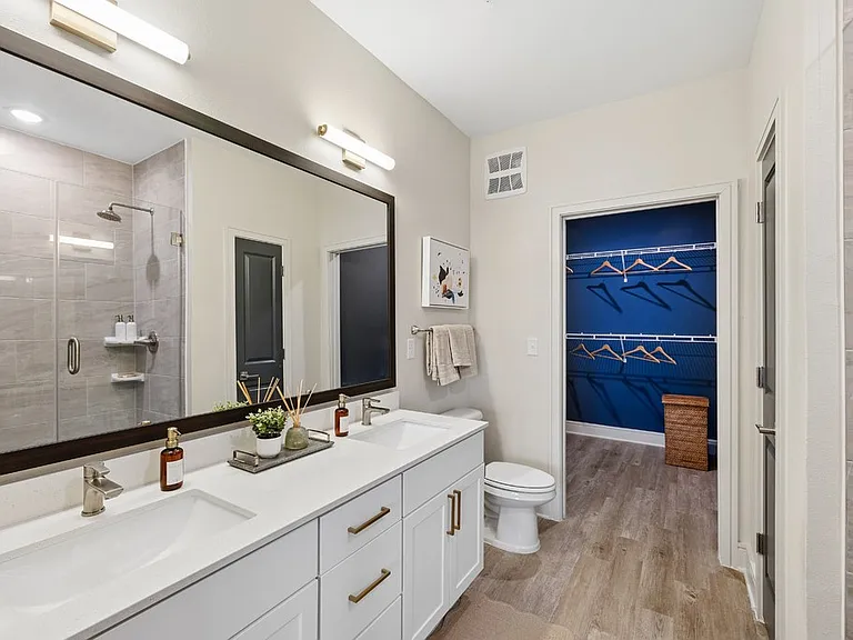 Bathroom with Quartz Countertops, Double Vanity Sinks, Walk-in Shower, and Walk-in Closet