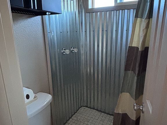 Large shower in bathroom with on-demand hot water heater for endless hot showers.