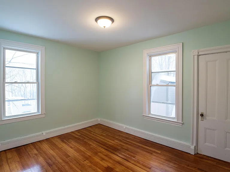 bedroom #4 off of kitchen featuring newly refinished hardwood floor, 2 large sunny windows and large closet