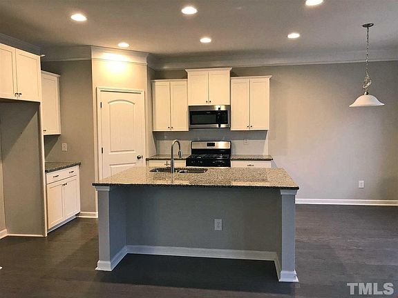 Crisp white kitchen with New Caledonia granite countertops
